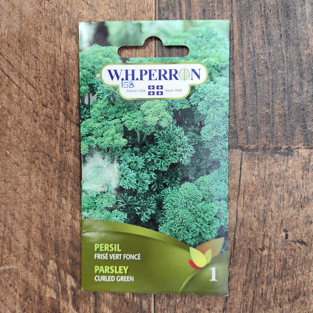 Sachet de semences W. H. Perron : Persil frisé vert foncé (Petroselinum crispum). L'emballage présente le nom de la sélection et une illustration de la plante ou de la récolte. Cette photographie montre la face avant du sachet, avec les renseignements imprimés visibles et les éléments graphiques qui permettent de reconnaître le produit parmi les autres semences de la gamme.