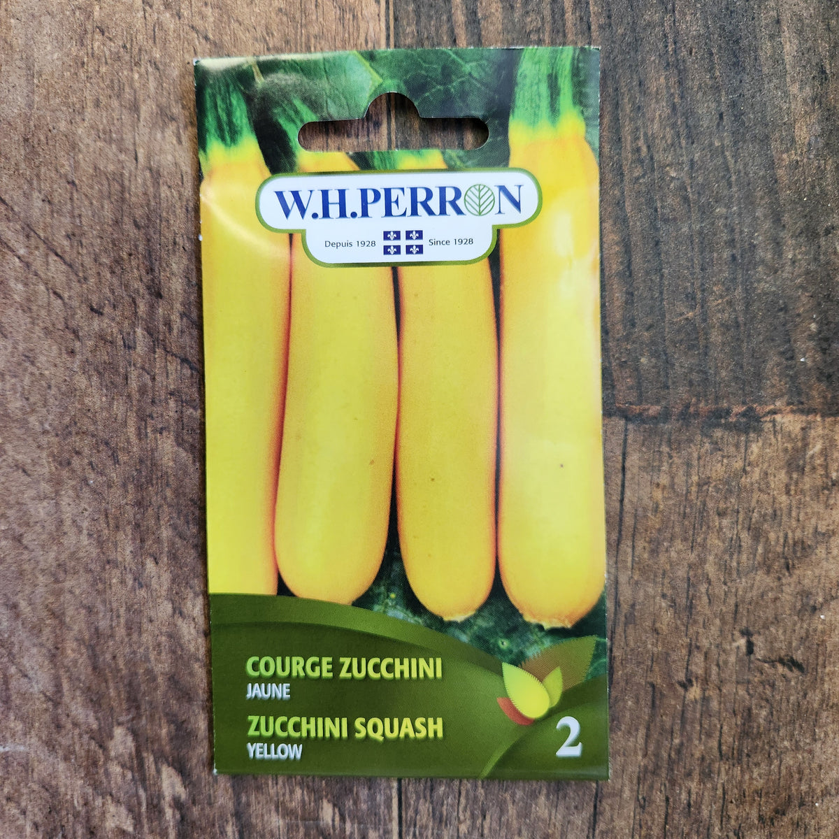 Sachet de semences W. H. Perron : Zucchini jaune (Cucurbita pepo). L'emballage présente le nom de la sélection et une illustration de la plante ou de la récolte. Cette photographie montre la face avant du sachet, avec les renseignements imprimés visibles et les éléments graphiques qui permettent de reconnaître le produit parmi les autres semences de la gamme.