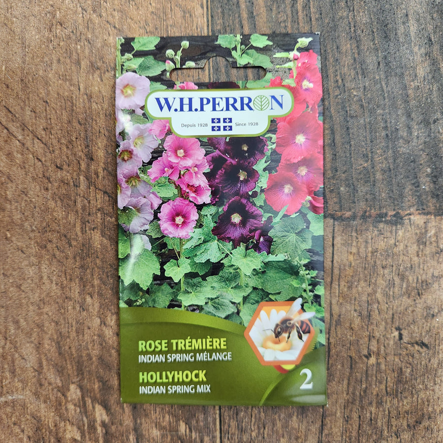 Sachet de semences W.H. Perron : Mélange de rose trémière (Alcea rosea ‘Indian Spring’). L’emballage présente le nom de la sélection et une illustration de la plante ou de la récolte. Cette photographie montre la face avant du sachet, avec les renseignements imprimés visibles et les éléments graphiques qui permettent de reconnaître le produit parmi les autres semences de la gamme.