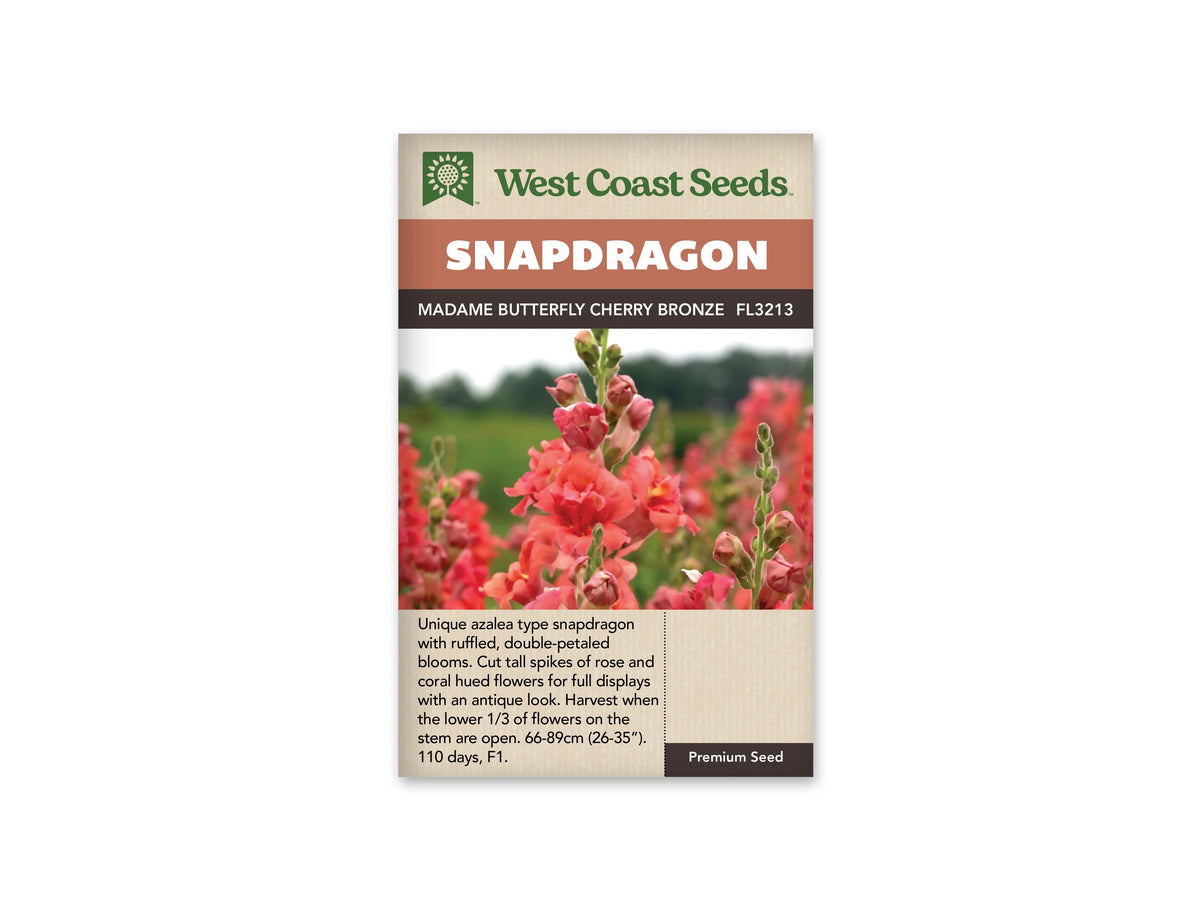 Sachet West Coast Seeds illustré par une photo de mufliers. Un épi de muflier porte des fleurs doubles aux pétales froncés, de couleur rose corail. Des boutons roses encore fermés prolongent son sommet. La tige verte apparaît entre les corolles, avec quelques feuilles étroites. À l’arrière, d’autres fleurs et du feuillage forment un fond flou qui laisse ressortir les détails de l’épi central.