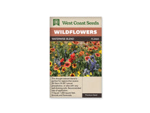 Sachet West Coast Seeds Waterwise Blend avec des fleurs rouge orangé bordées de jaune, des corolles rouges en coupe et des épis bleu violet. Le feuillage vert remplit les espaces entre les tiges. Plusieurs têtes rondes encore fermées sont visibles dans la plantation. La photo montre un massif dense, dominé par des couleurs chaudes et bleues.