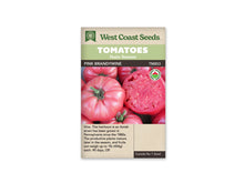 Sachet West Coast Seeds portant les mentions Tomatoes, Main Season et Pink Brandywine. La photo montre de grosses tomates roses aux épaules côtelées, avec des pédoncules verts, et un fruit coupé qui révèle la chair. Un logo biologique rond apparaît à droite. Le nom et le code TM853 sont placés sous les bandeaux verts.