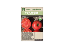 Sachet West Coast Seeds portant les mentions Tomatoes, Main Season et Damsel. La photo montre une tomate rose rouge entière et des coupes du fruit sur une surface sombre. La chair et les loges sont bien visibles. Un logo biologique rond apparaît à droite. Le nom figure sur une bande foncée sous le bandeau vert.
