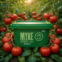 Contenant de MYKE Potager et fines herbes mycorhizes placé au cœur d’un jardin de tomates abondant, entouré de tomates rouges mûres et d’un feuillage dense.