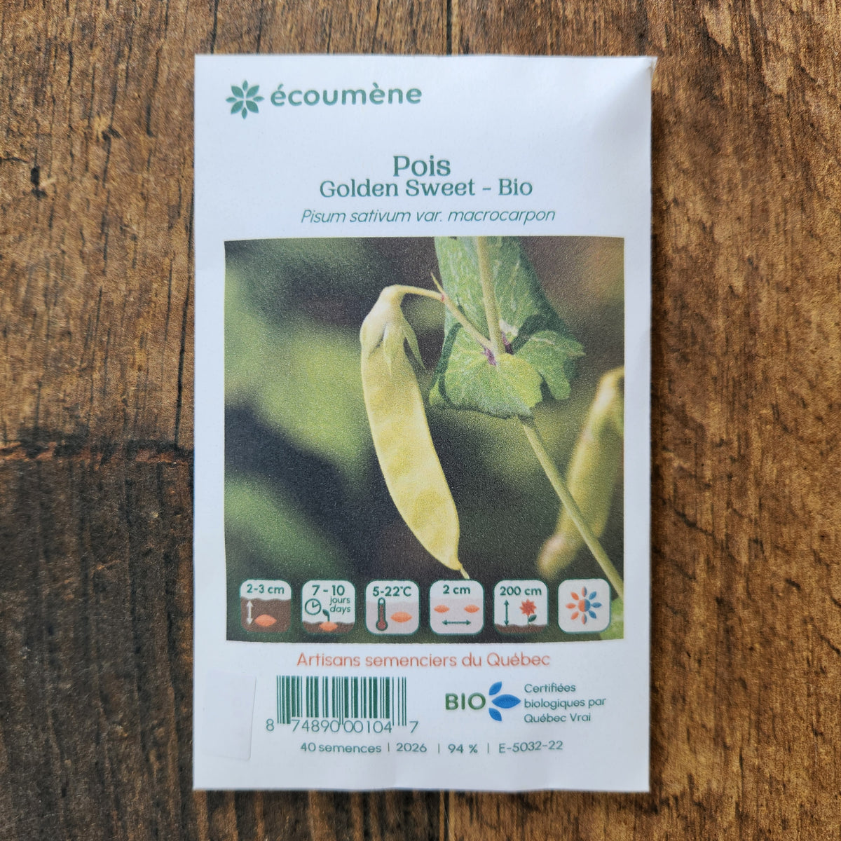 Sachet de semences Pois Golden Sweet. Emballage blanc photographié de face sur un fond de bois brun. Une image du végétal occupe la partie centrale, sous le nom imprimé. De petits pictogrammes et un code-barres apparaissent au bas du sachet. La marque Écoumène figure dans la partie supérieure de cette présentation.