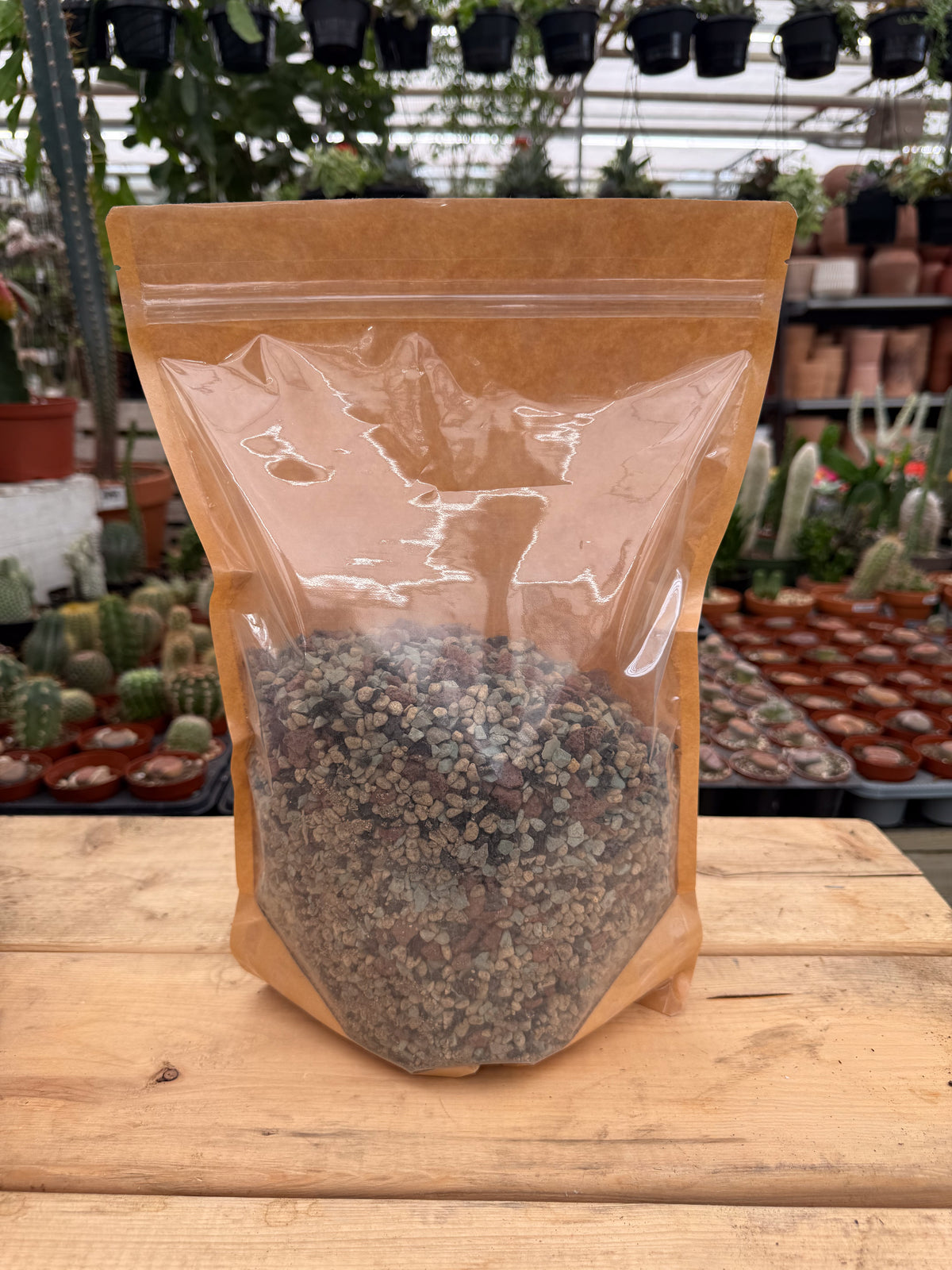 Sac transparent de mélange Hydro-roche Gaïand Pon présenté en serre sur une table avec des cactus en arrière-plan