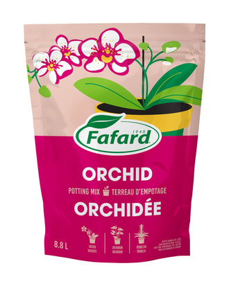 Sac de terreau d'empotage Fafard Orchid Potting Mix pour orchidées, emballage rouge avec illustration d'orchidée blanche et verte, posé sur étagère en bois entouré de plants d'orchidées Phalaenopsis en fleurs roses, blanches et violettes dans une serre au Québec