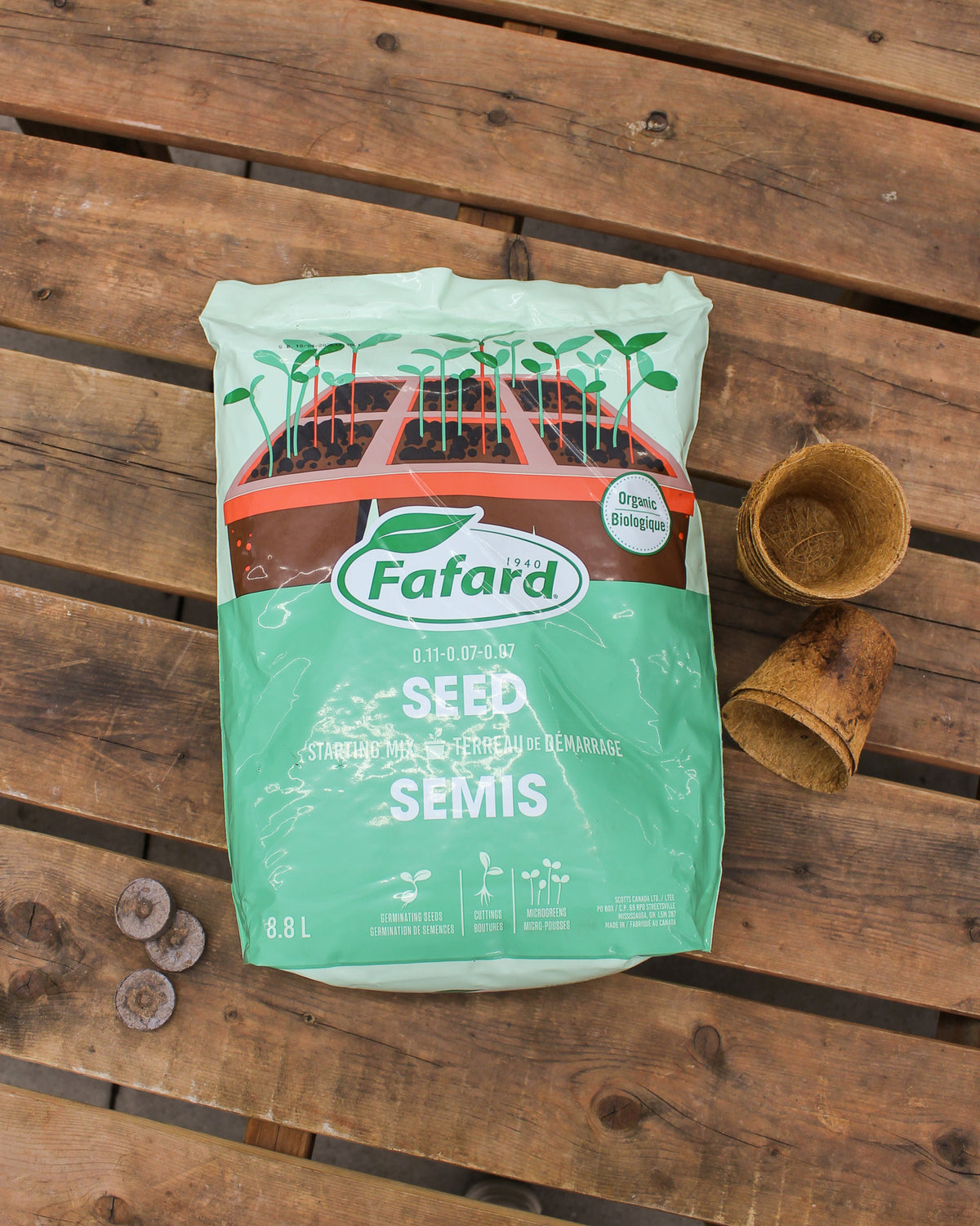 Sac de terreau de démarrage pour semis biologique Fafard 8,8 L posé sur une table en bois avec godets biodégradables