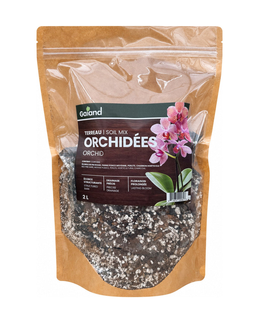 Sac de terreau pour orchidées Gaïand 2 L présenté en serre avec plusieurs orchidées en fleurs