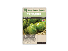 Sachet West Coast Seeds avec les mentions Tomatoes, Main Season et Green Zebra. La photo montre plusieurs tomates rondes vertes et jaunes, marquées de rayures vert foncé, dans un panier clair. Un logo biologique rond apparaît à droite. La bande sombre porte le nom de la variété, sous les bandeaux verts de la marque.