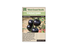 Sachet West Coast Seeds avec les mentions Tomatoes, Main Season et Indigo Rose. La photo montre des tomates rondes très sombres, bleu pourpre à presque noires, sur une tige. Quelques feuilles vertes et un fond clair sont visibles derrière les fruits. Un logo biologique rond figure à droite, sous le bandeau du nom.