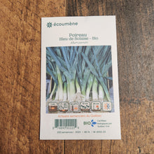 Sachet de semences Poireau Bleu de Solaise. Emballage blanc photographié de face sur un fond de bois brun. Une image du végétal occupe la partie centrale, sous le nom imprimé. De petits pictogrammes et un code-barres apparaissent au bas du sachet. La marque Écoumène figure dans la partie supérieure de cette présentation.